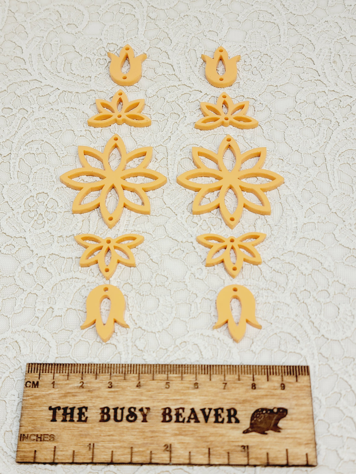 Two 5-tier acrylic flower earring sets in apricot, laid out top to bottom beside a ruler