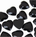Pile of 20mm faceted black resin heart gem cabochons (cabs), one flipped to show the flat back