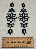 Two 5-tier acrylic flower earring sets in black, laid out top to bottom beside a ruler