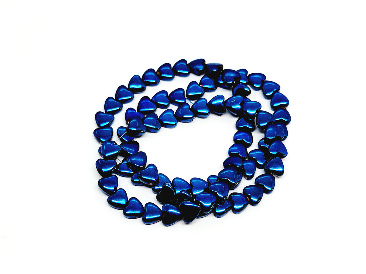 Strand of 6mm blue hematite heart beads coiled on a white background