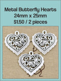 Three silver-tone 24 x 25mm filigree heart charms with a butterfly cut-out