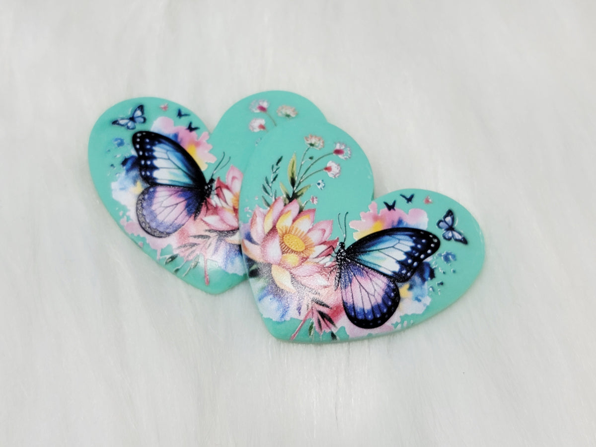 Pair of 37mm resin heart cabochons (cabs) in mint with blue butterflies and a pink lotus flower