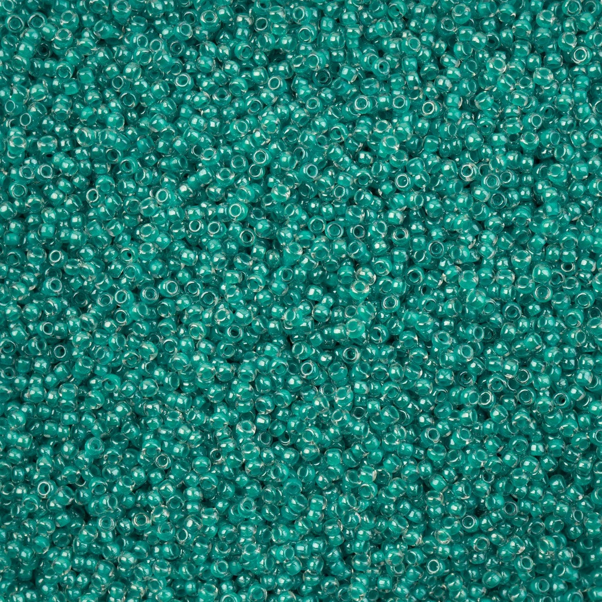 Close-up of Preciosa 11/0 Czech glass seed beads in crystal green colour-lined with a luster finish