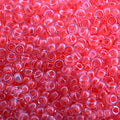 Close-up of Miyuki 11/0 glass seed beads in colour-lined flamingo luminous neon