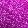 Close-up of Miyuki 11/0 glass seed beads in colour-lined fuchsia luminous neon