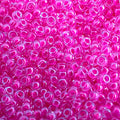 Close-up of Miyuki 11/0 glass seed beads in colour-lined hot pink luminous neon