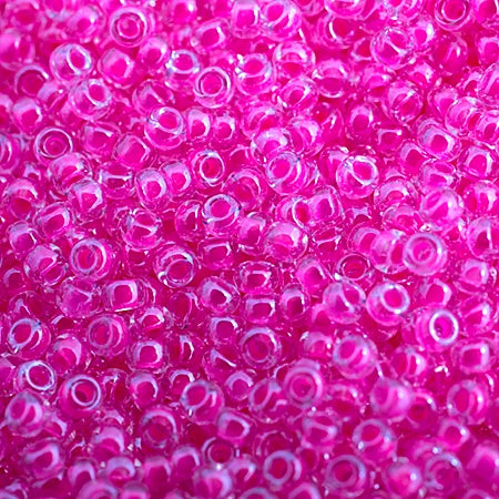 Close-up of Miyuki 11/0 glass seed beads in colour-lined hot pink luminous neon
