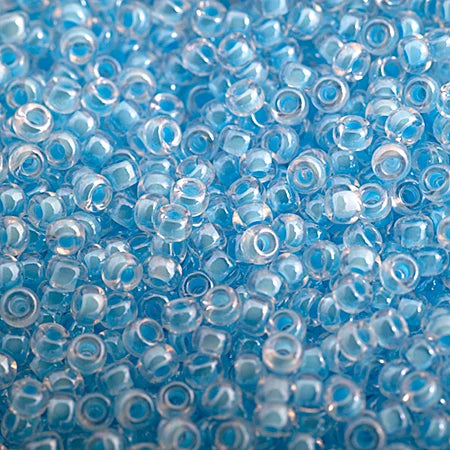 Close-up of Miyuki 11/0 glass seed beads in colour-lined light blue luminous neon