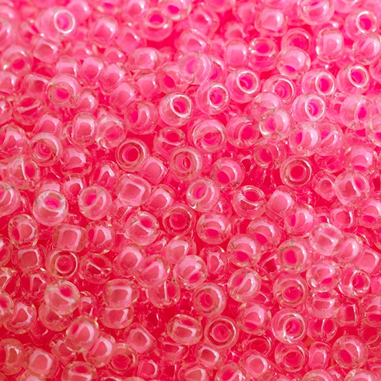 Close-up of Miyuki 11/0 glass seed beads in colour-lined pink luminous neon