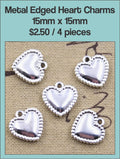 Four silver-tone 15 x 15mm puffed heart charms with a beaded edge