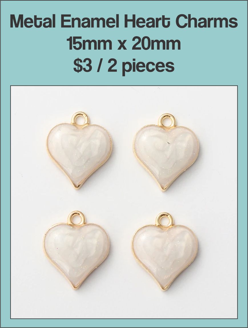 Two gold-edged 15 x 20mm heart charms filled with cream enamel