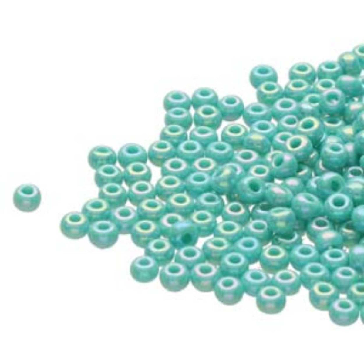 Small pile of Preciosa 11/0 Czech glass seed beads in opaque green turquoise with an AB rainbow finish on a white background