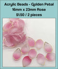 Pile of 16 x 23mm acrylic petal charms in pale rose with gold-tone edges
