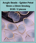 Pile of 16 x 23mm acrylic petal charms in smoky blue-grey with gold-tone edges