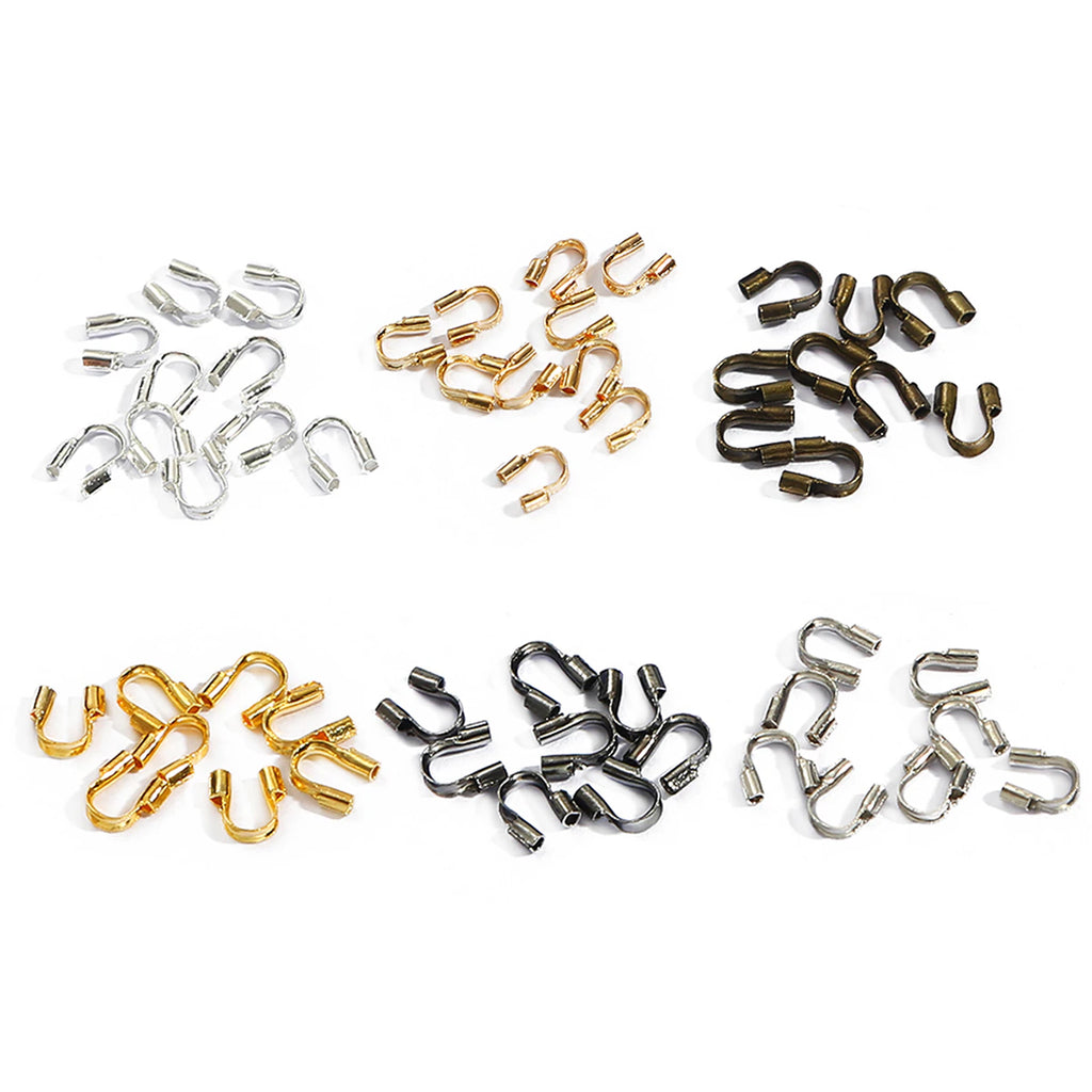 Wire guards in silver, gunmetal, gold, copper and bronze, in small piles on white