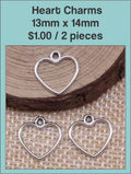 Silver-tone open 13 x 14mm heart charms on burlap on a labelled product card