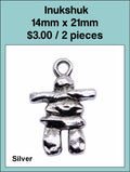 Silver-tone 14 x 21mm inukshuk charm with a loop at the top on a labelled product card