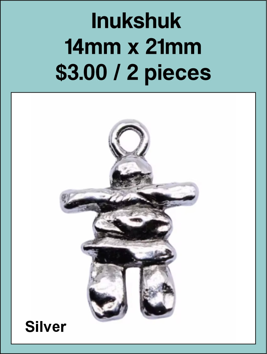 Silver-tone 14 x 21mm inukshuk charm with a loop at the top on a labelled product card
