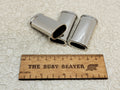 Three blank silver J5 lighter cases with ridged edges beside a ruler