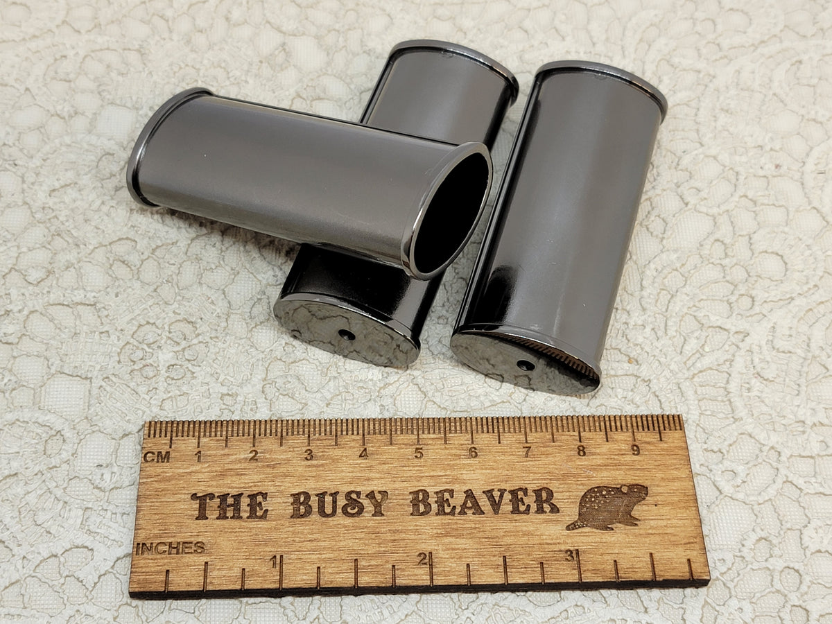 Blank gunmetal J6 lighter cases with ridged edges, standing and lying down