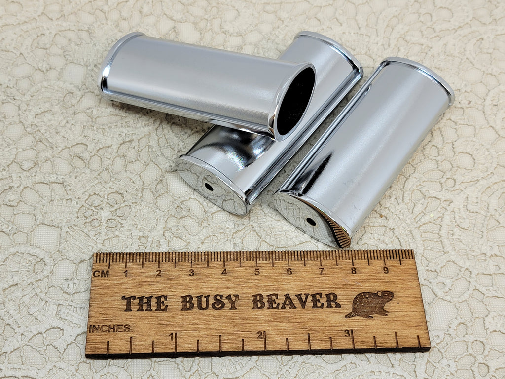 Pair of blank silver J6 lighter cases with ridged edges beside a ruler
