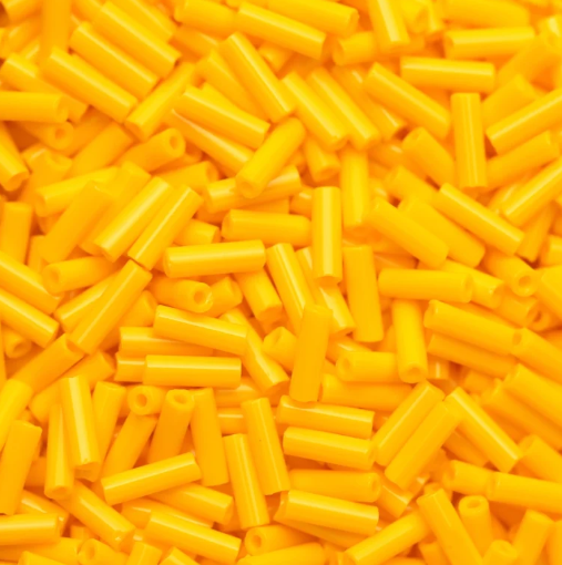 Close-up of loose 6mm Preciosa Czech glass bugle beads in light orange