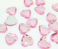 Pile of 20mm faceted light pink resin heart gem cabochons (cabs), one flipped to show the flat back