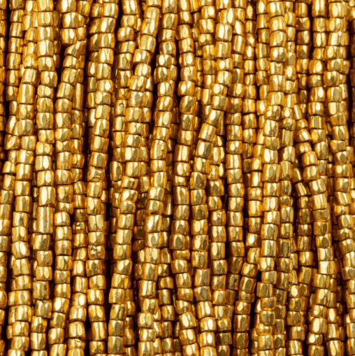 Close-up of strung Preciosa 9/0 three-cut glass seed beads in metallic light gold