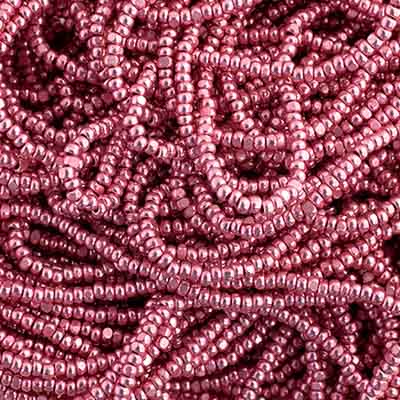 Close-up of strung Preciosa 13/0 true cut charlotte beads in metallic pink terra