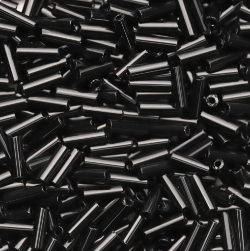 Close-up of loose 6mm Preciosa Czech glass bugle beads in opaque black