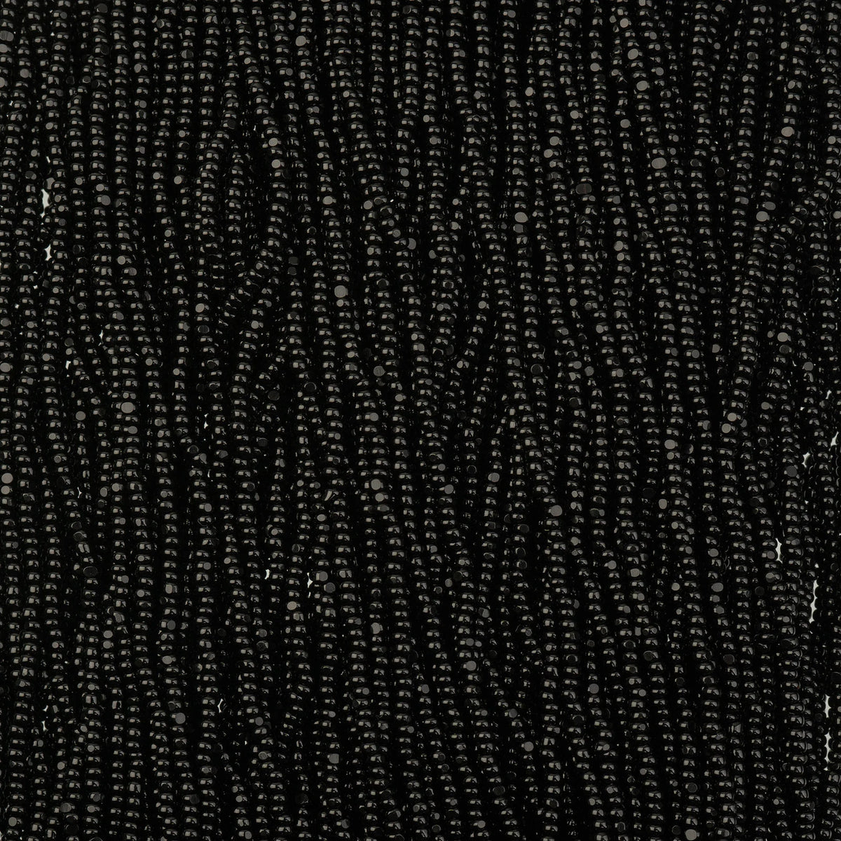 Close-up of strung Preciosa 13/0 true cut charlotte beads in opaque black