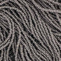 Close-up of strung Preciosa 13/0 true cut charlotte beads in opaque grey