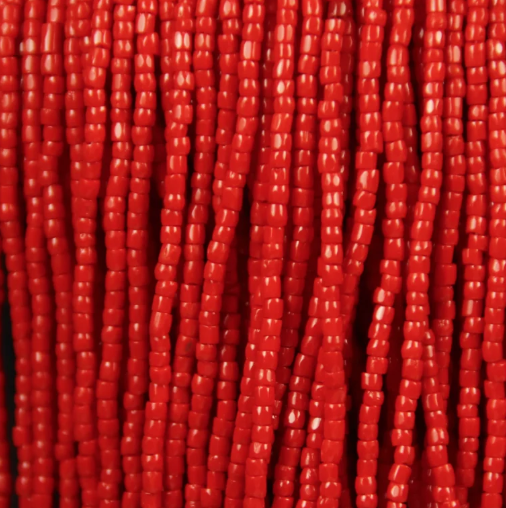 Close-up of strung Preciosa 9/0 three-cut glass seed beads in opaque light red