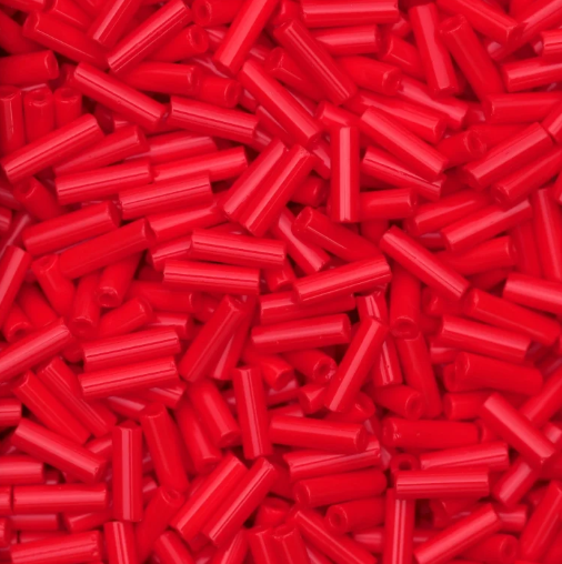 Close-up of loose 6mm Preciosa Czech glass bugle beads in opaque light red