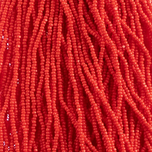 Close-up of strung Preciosa 13/0 true cut charlotte beads in opaque light red