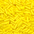 Close-up of loose 6mm Preciosa Czech glass bugle beads in opaque light yellow