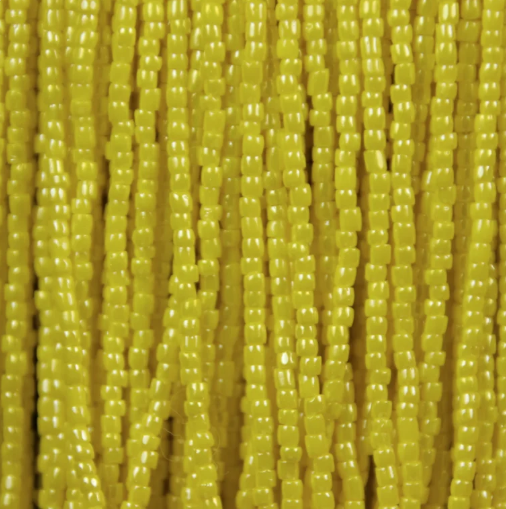 Close-up of strung Preciosa 9/0 three-cut glass seed beads in opaque light yellow with a luster finish