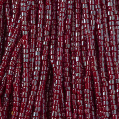Close-up of strung Preciosa 9/0 three-cut glass seed beads in opaque red with a luster finish