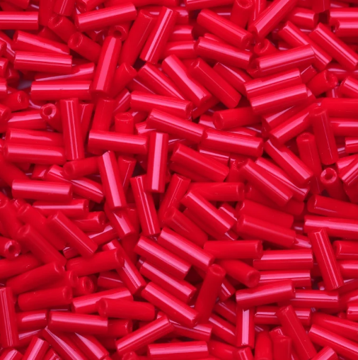 Close-up of loose 6mm Preciosa Czech glass bugle beads in opaque medium red