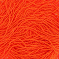 Close-up of strung Preciosa 13/0 true cut charlotte beads in opaque orange