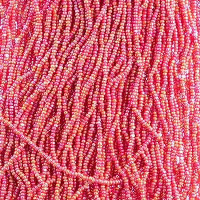 Close-up of strung Preciosa 13/0 true cut charlotte beads in opaque ruby with an AB rainbow finish