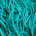 Close-up of strung Preciosa 13/0 true cut charlotte beads in opaque turquoise