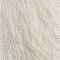 Close-up of strung Preciosa 13/0 true cut charlotte beads in opaque white with a luster finish