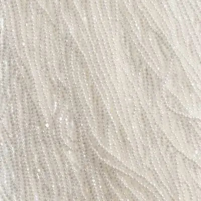 Close-up of strung Preciosa 13/0 true cut charlotte beads in opaque white with a luster finish