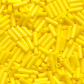 Close-up of loose 6mm Preciosa Czech glass bugle beads in opaque yellow