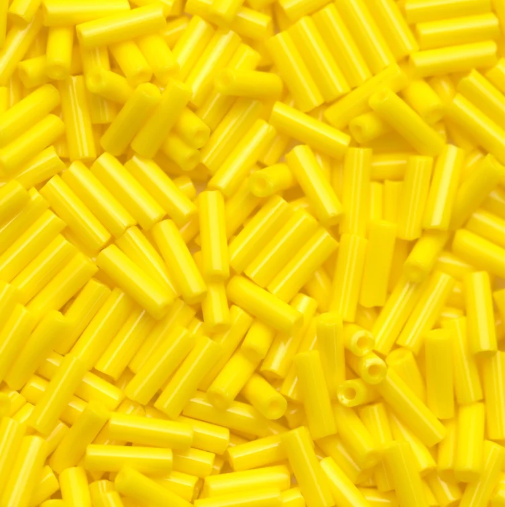 Close-up of loose 6mm Preciosa Czech glass bugle beads in opaque yellow