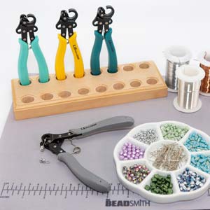 1 Step Looper pliers with wire, tools and a case of beads on a work table