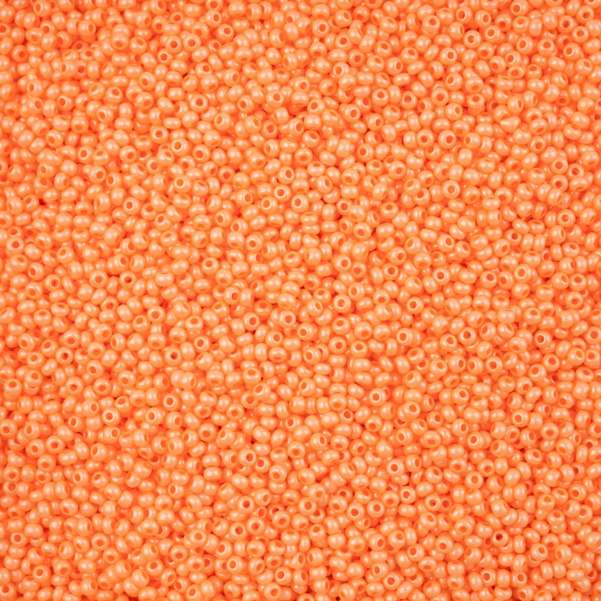 Close-up of Preciosa 11/0 Czech glass seed beads in pearl orange chalk terra intensive with a luster finish