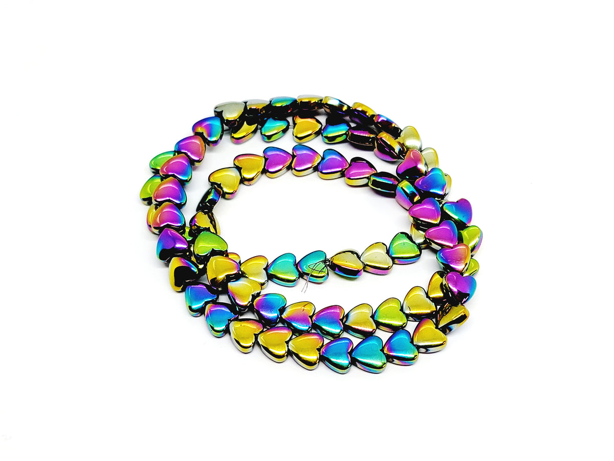 Strand of 6mm rainbow hematite heart beads coiled on a white background