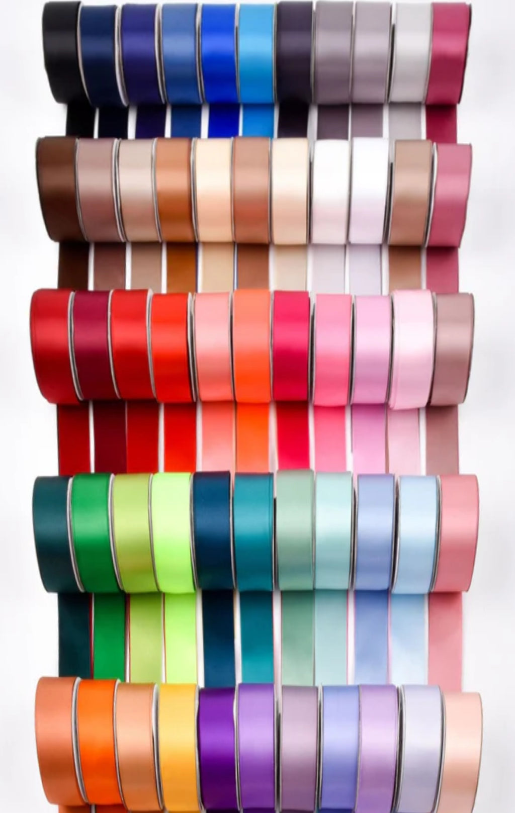 Stacked rolls of single-faced satin ribbon in a rainbow of colours